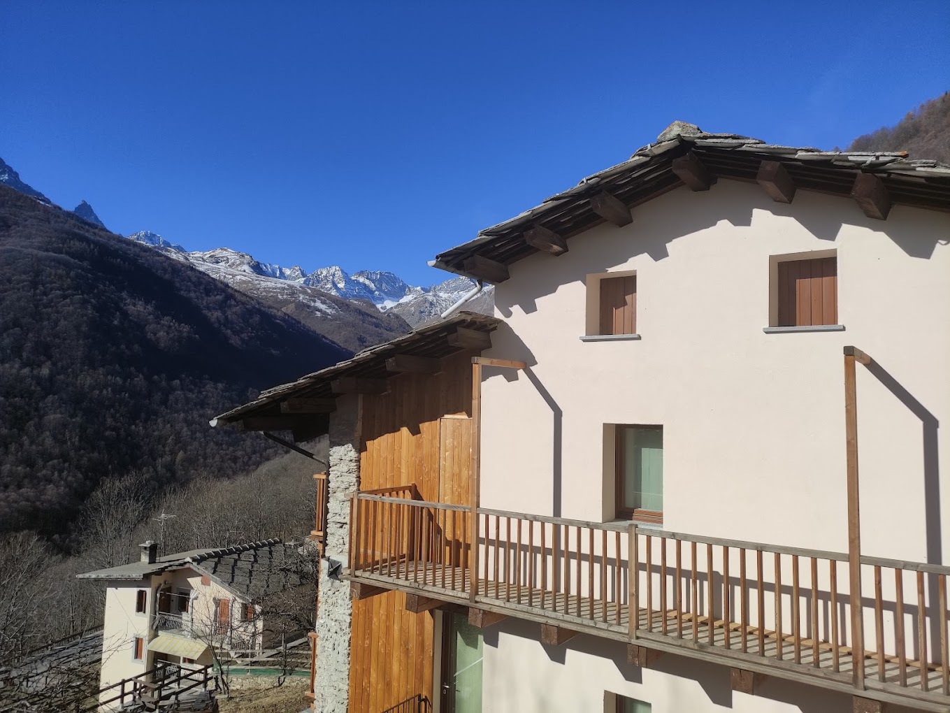 La casa di montagna del Faunet con ballatoio in legno e vista sulle montagne della Valle Po