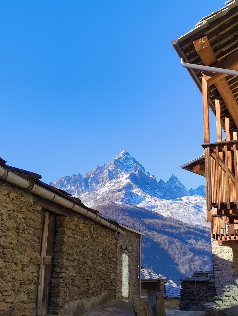 Vicolo in pietra della borgata con il Monviso sullo sfondo